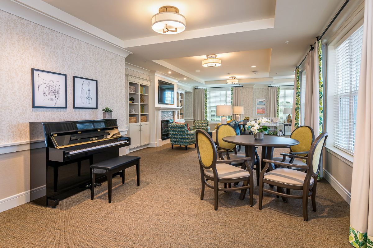 A spacious living room with a piano and dining area, elegantly furnished and well-lit.