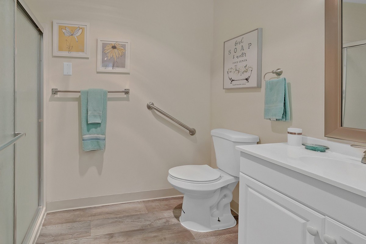 A clean and modern bathroom with a toilet, sink, and decorative elements.