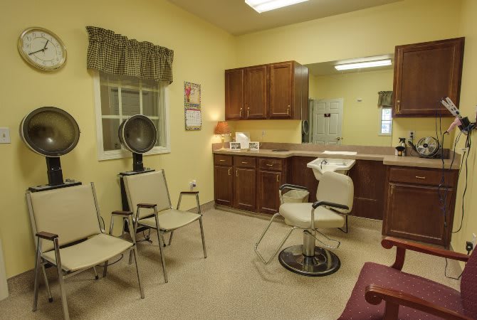 A cozy hair salon with styling chair and hairdryer setup.