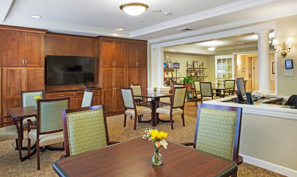 A well-furnished dining area with wooden cabinets, tables, and chairs.