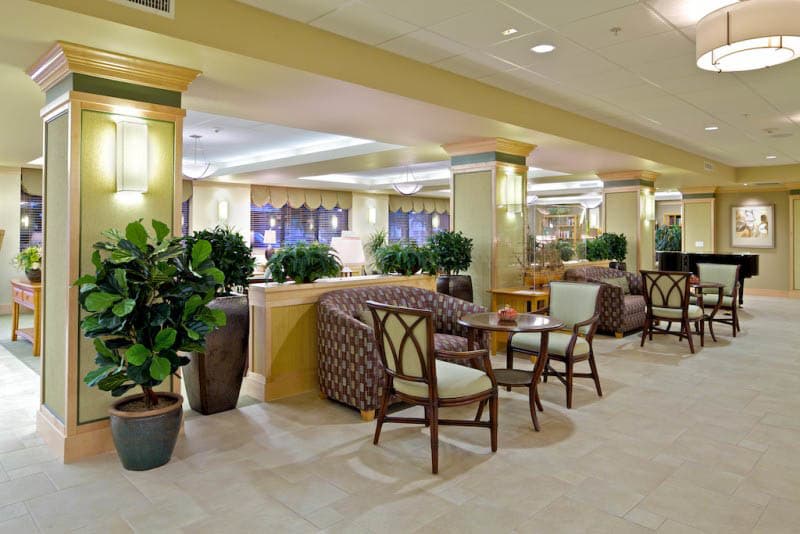 A spacious hotel lobby with comfortable seating and lush plants.