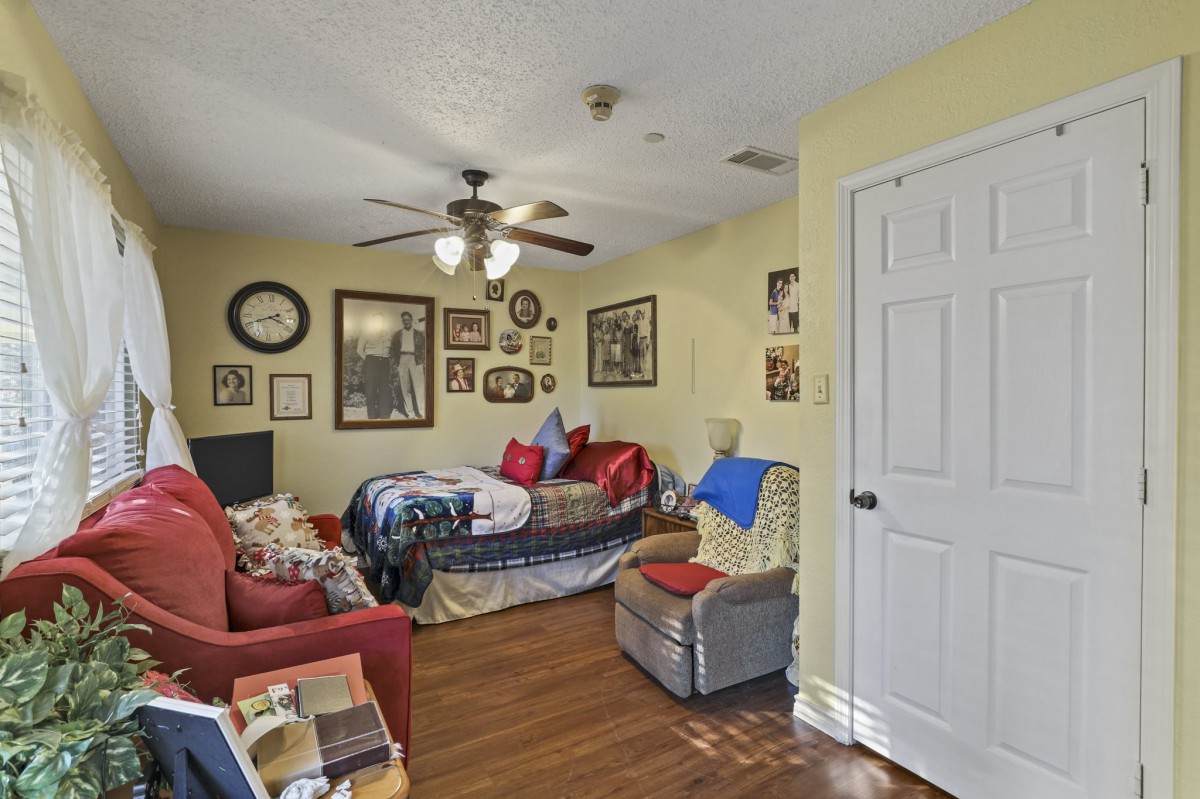 A cozy living room with a couch, chair, and various decorations on the walls.