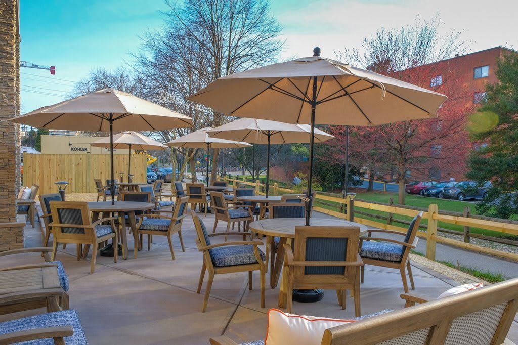 An inviting outdoor seating area with tables and umbrellas on a sunny day.