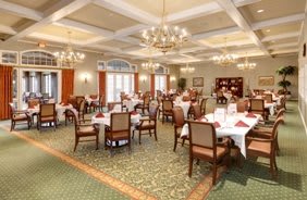 An elegant dining room with neatly arranged tables and chandeliers.