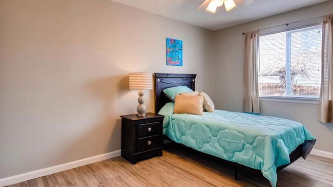 A cozy bedroom with a single bed, nightstand, and decorative elements.