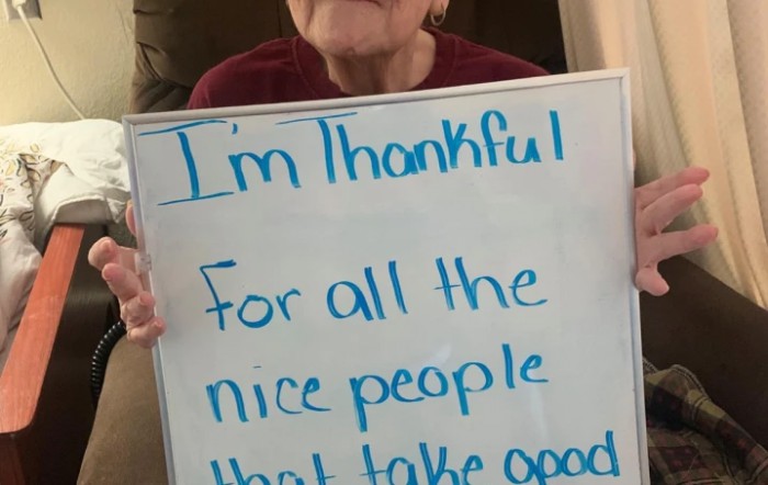A person holding a whiteboard with a thankful message.
