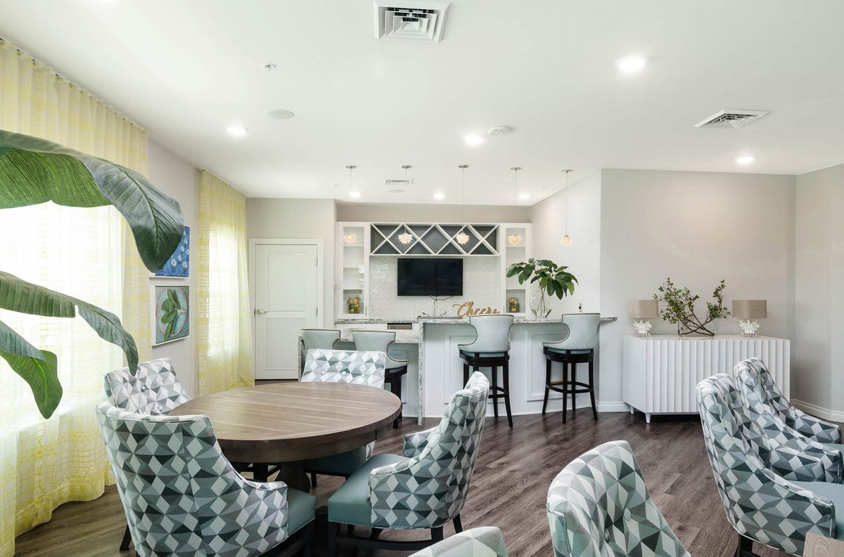 A modern, open-concept living area featuring a bar with seating and stylish decor.
