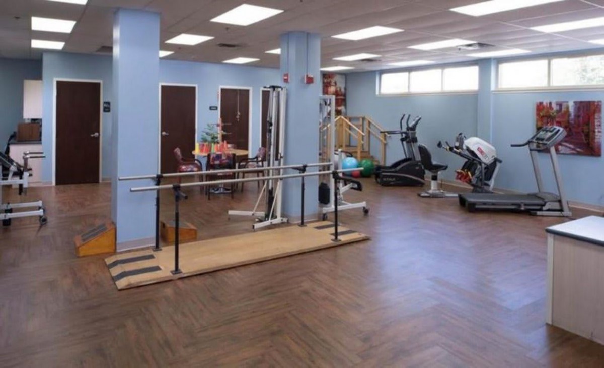 A physical therapy room with various exercise equipment and rehabilitation tools.