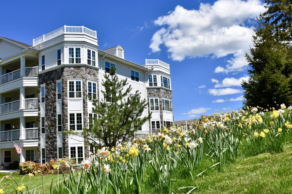 A picturesque view of a building surrounded by blooming flowers under a bright blue sky.
