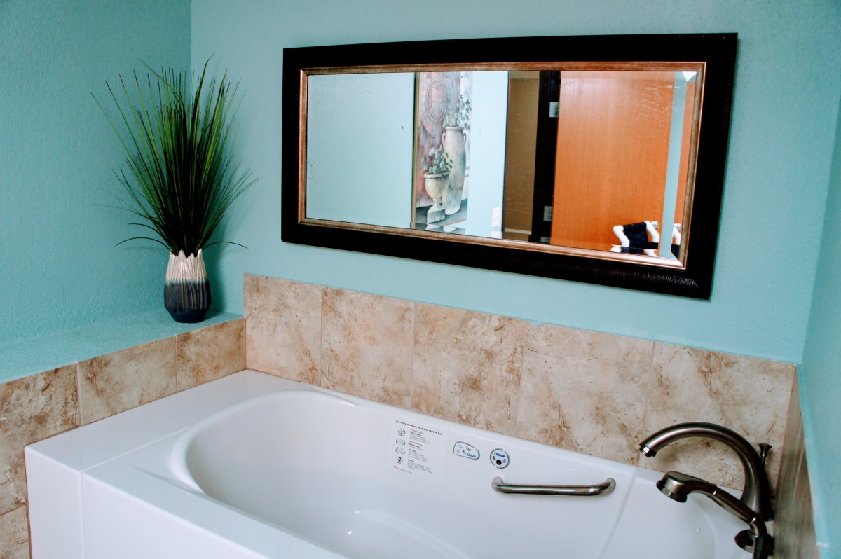 A modern bathroom featuring a bathtub with a tiled wall and elegant decor.