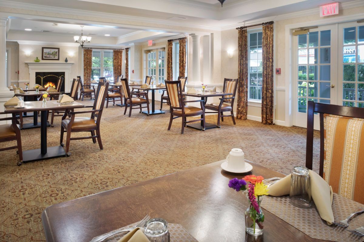 A spacious and elegantly designed dining room with neatly arranged tables and chairs, creating a welcoming atmosphere.