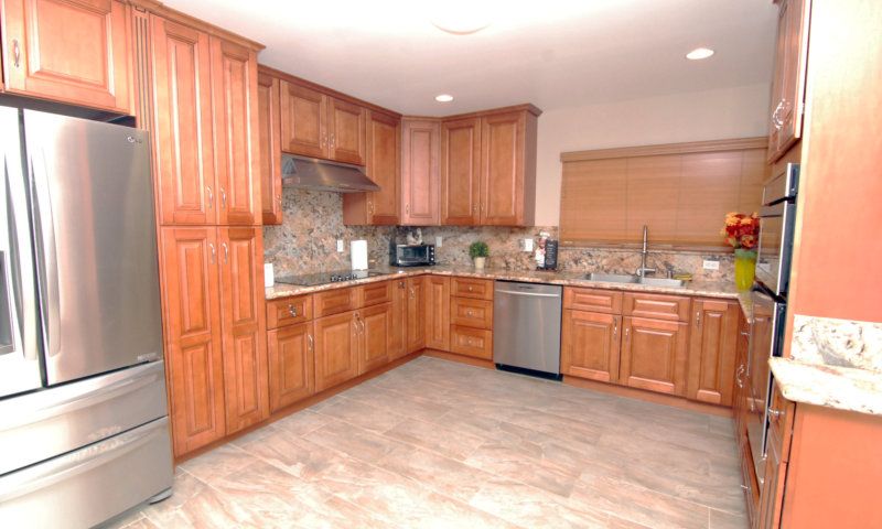 A modern kitchen with wooden cabinets and stainless steel appliances.