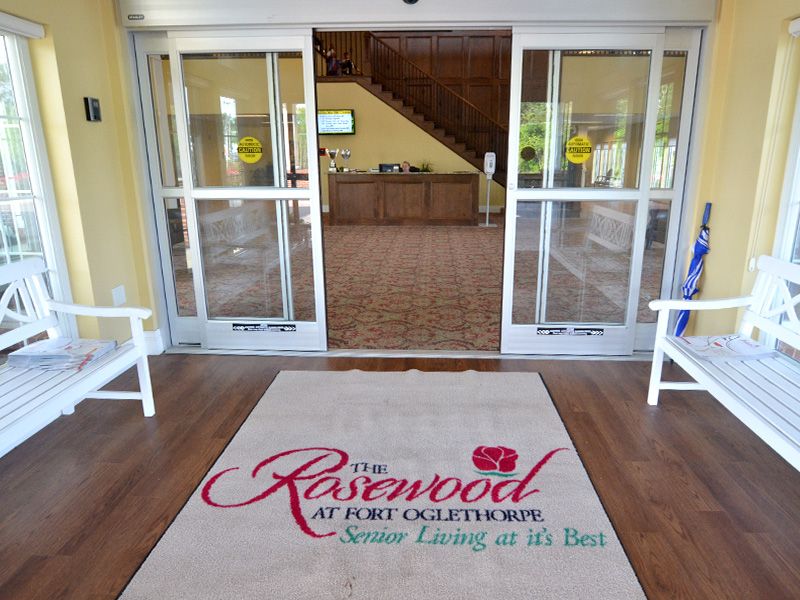 Entrance to a senior living facility with a welcoming mat.