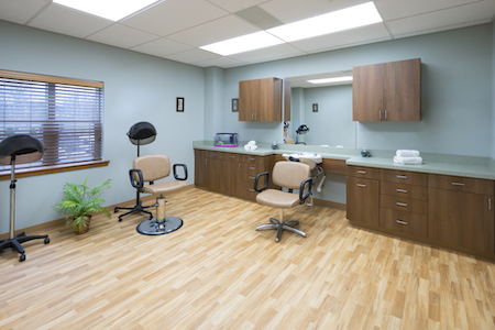 A well-lit interior of a hair salon featuring stylist chairs and a vanity area.