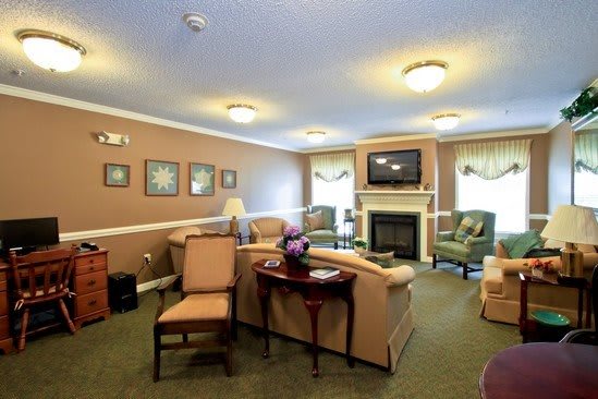 A cozy living room with comfortable seating, a fireplace, and a television.