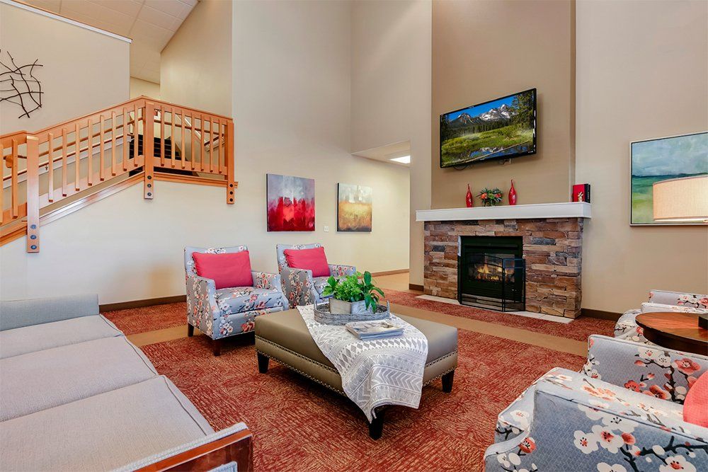 A cozy living room featuring a fireplace, comfortable seating, and decorative artwork.