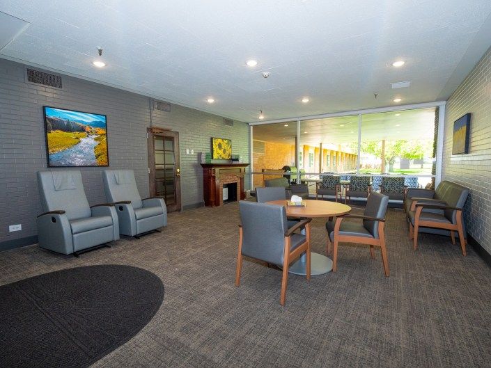 A modern and comfortable waiting room with several chairs and tables.