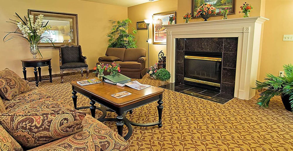 A cozy living room with a sofa and coffee table in front of a fireplace.
