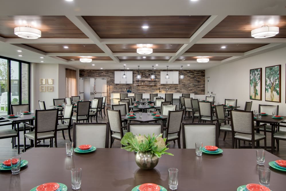 A spacious and elegantly designed dining or meeting area with neatly arranged tables and chairs.