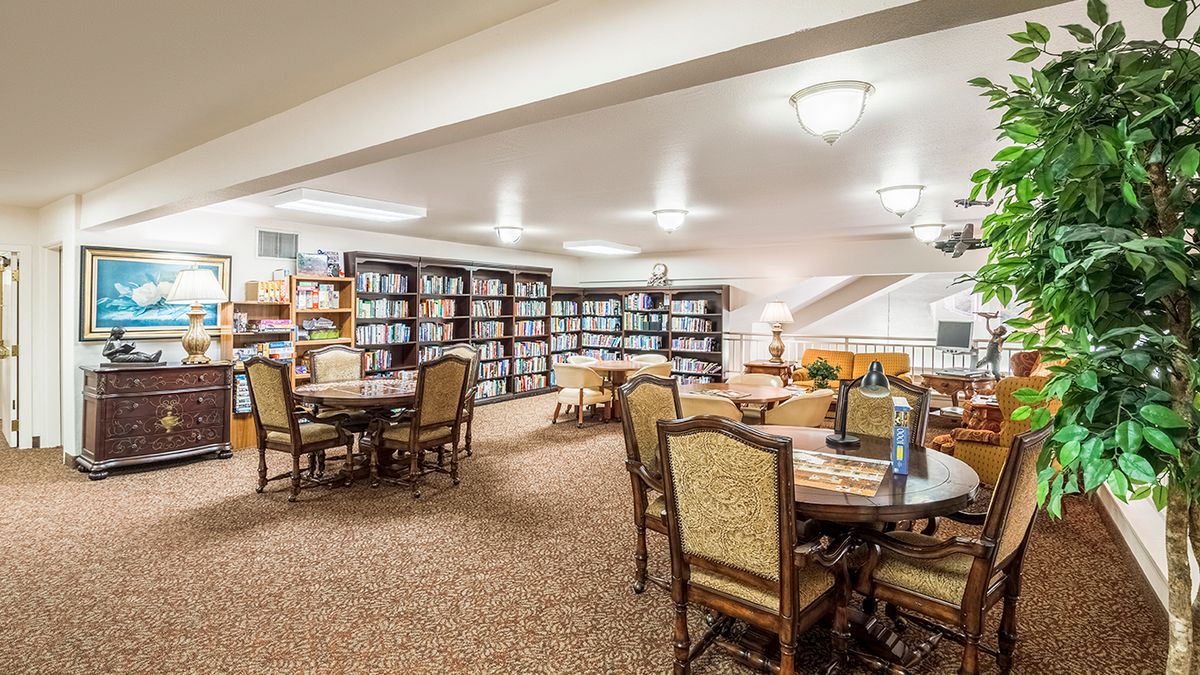 A cozy library room with bookshelves and reading tables.
