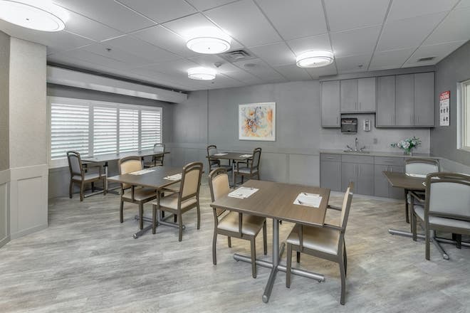 A modern dining area with multiple tables and chairs, featuring soft lighting and contemporary interior design.