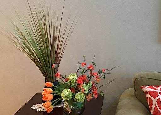 A beautifully arranged table centerpiece featuring vibrant artificial flowers and decorative plants.