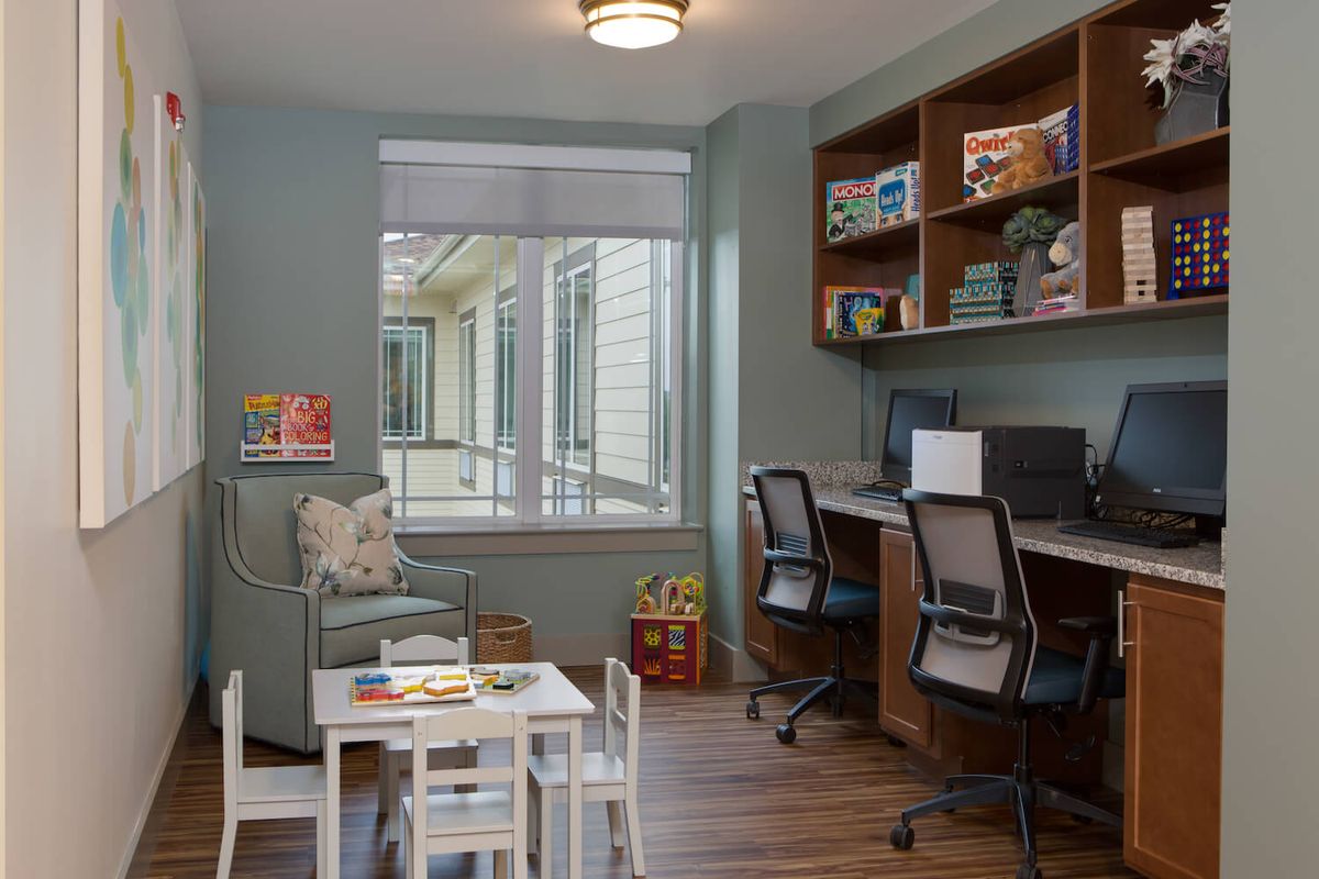 A cozy study room with a children's play area and workstations.