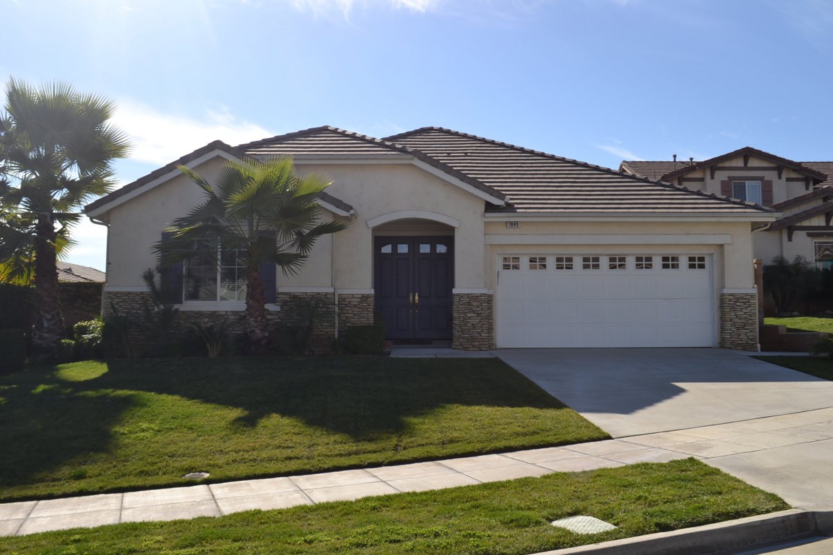 A single-story suburban house with a neatly maintained lawn and a two-car garage.