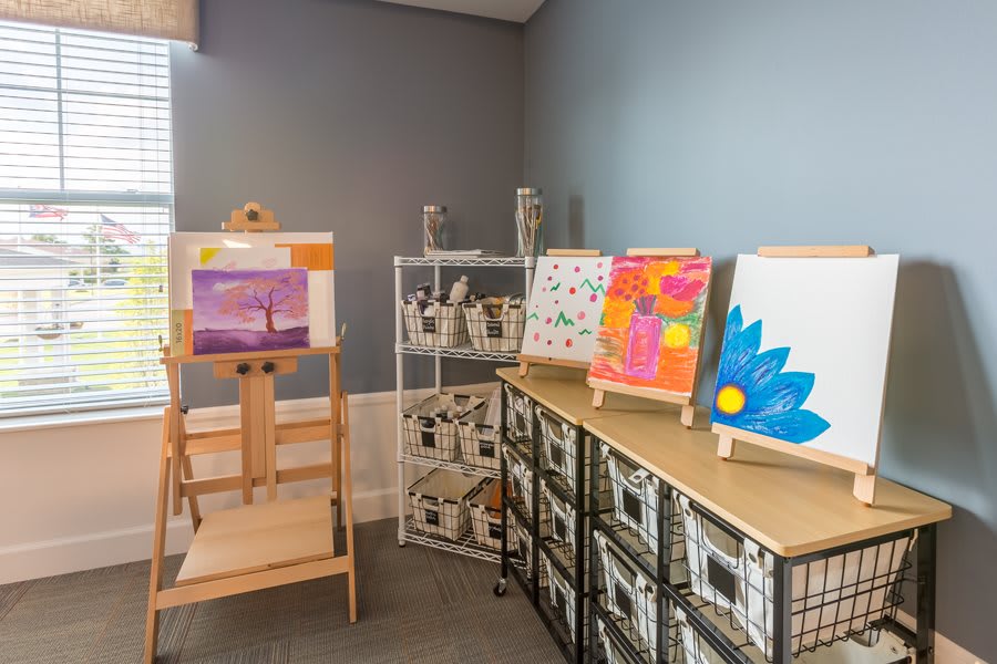 A cozy art studio corner featuring colorful paintings on display.
