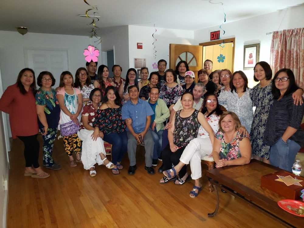 A large group of people posing together indoors for a group photo during a gathering.