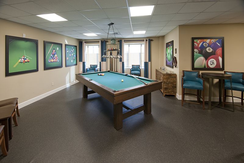 A well-designed recreation room featuring a pool table and comfortable seating.