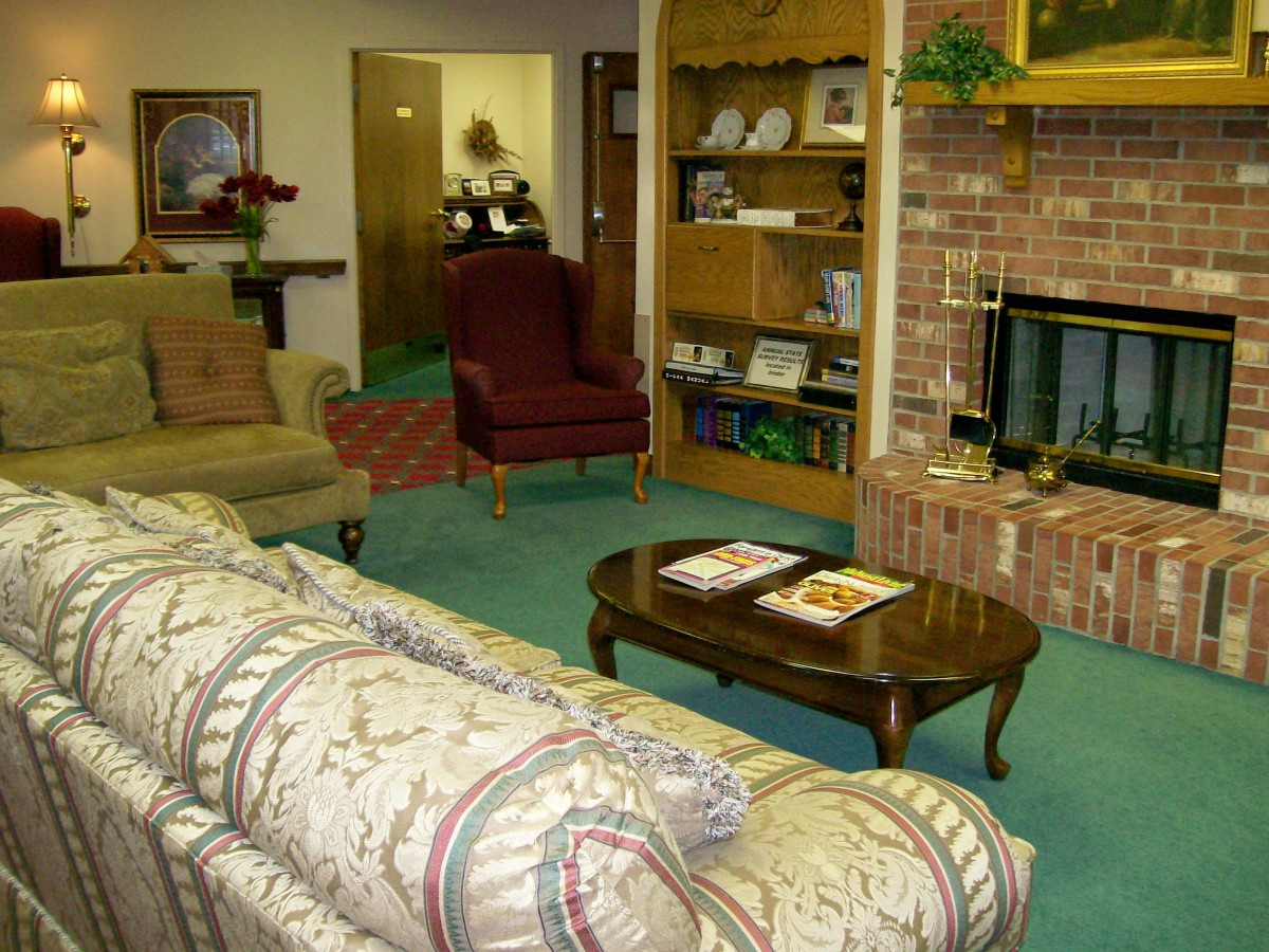A cozy living room with a sofa, armchairs, and a brick fireplace.
