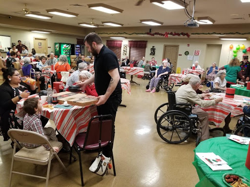 A lively community gathering at a senior center, where residents enjoy meals and engage in social activities.