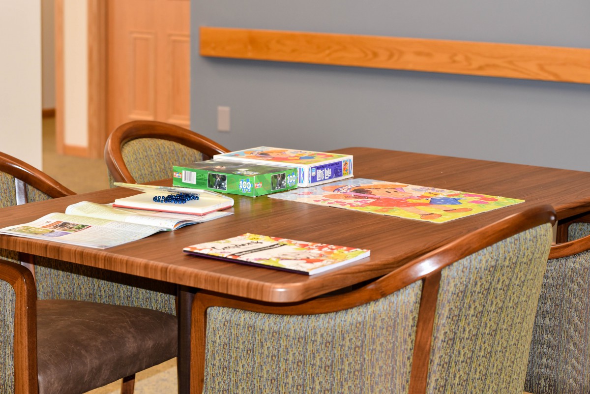 A table with books and magazines in a cozy room.
