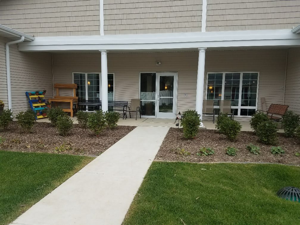 A well-maintained patio with a walkway and garden area in front of a building.