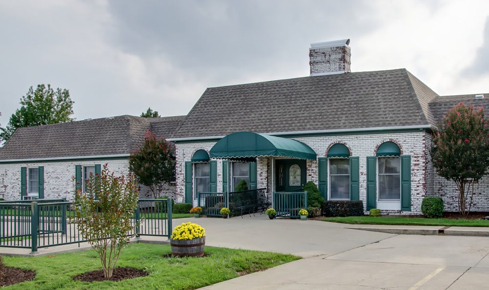 A quaint restaurant with a green awning and landscaped surroundings.