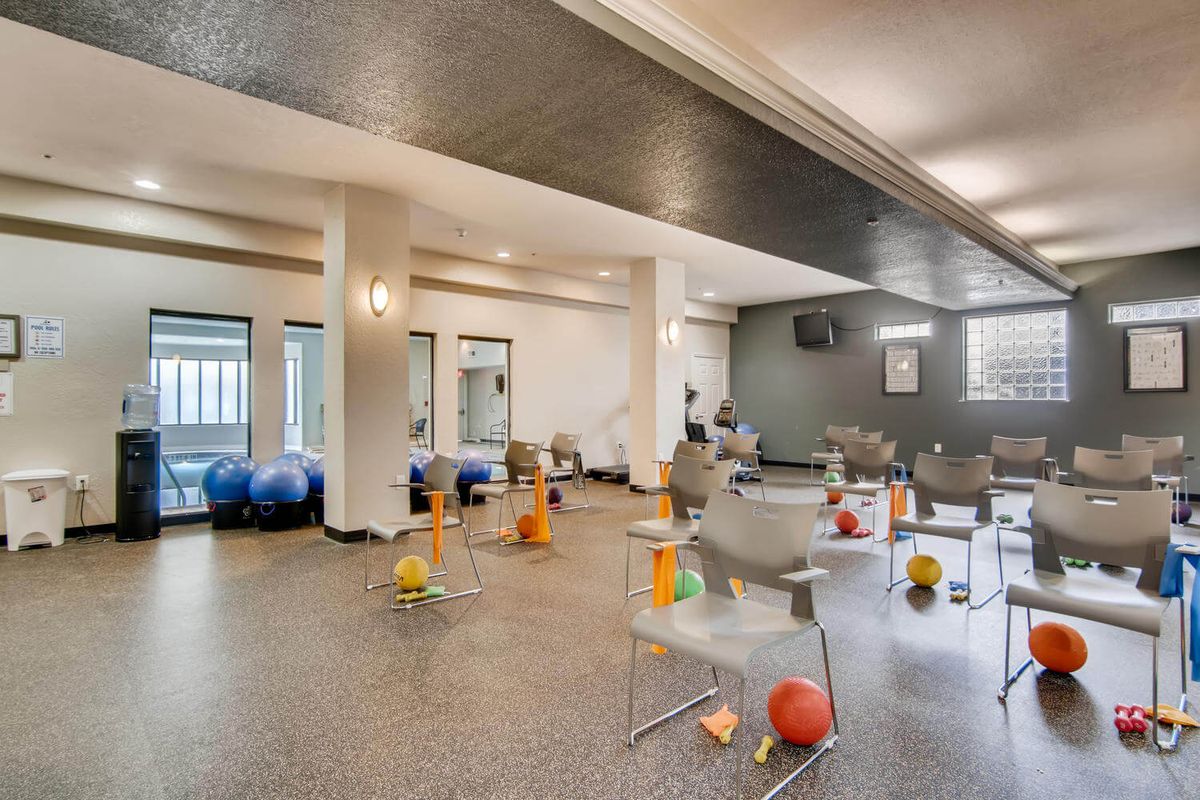 A well-equipped exercise room featuring therapy balls and chairs, ideal for fitness or rehabilitation activities.