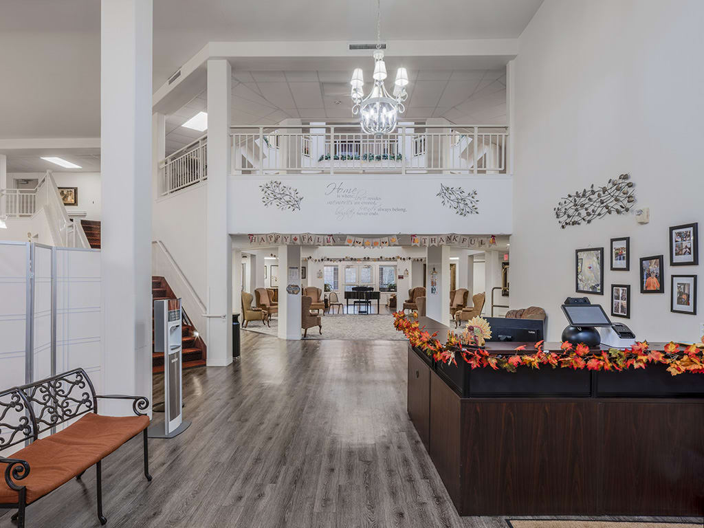 A spacious and modern lobby with a chandelier and decorated reception desk.