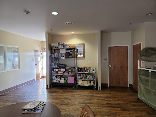 A cozy interior space featuring shelves filled with books and a wooden floor.