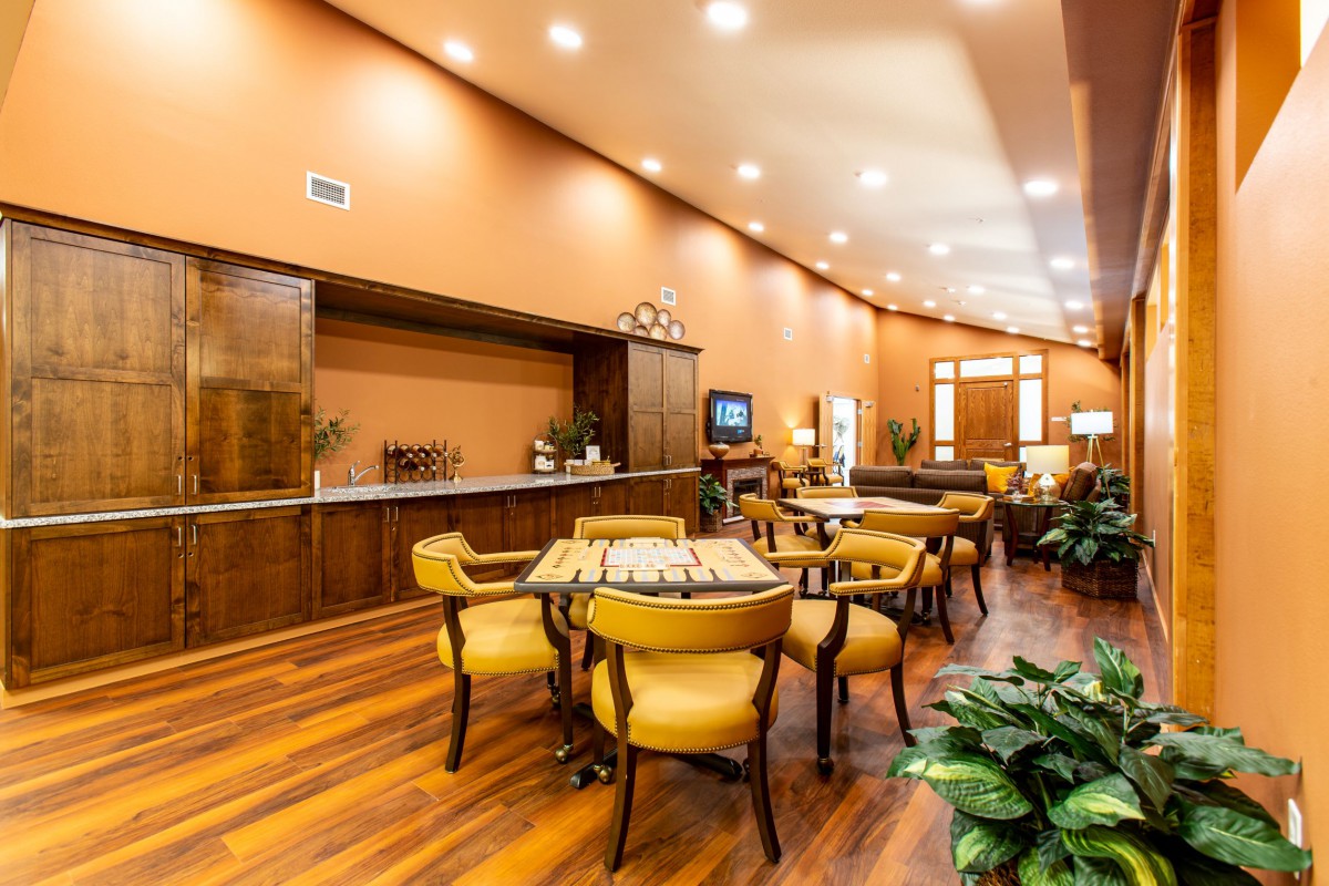 A stylish dining area with wooden flooring, elegant seating, and warm lighting.