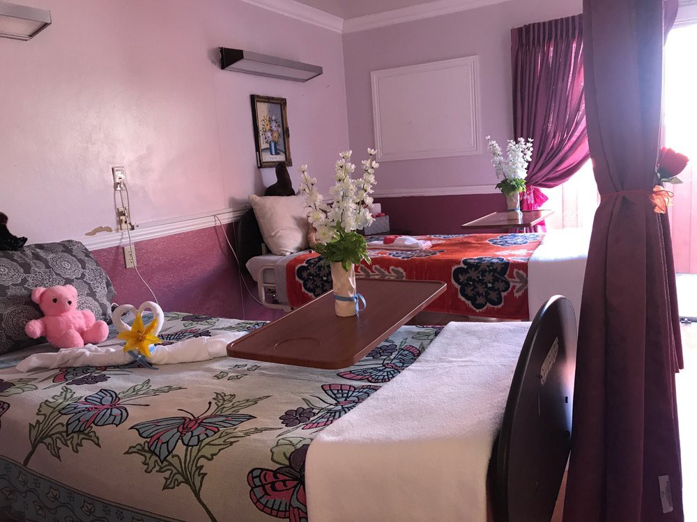 A cozy hotel room with beautifully decorated beds and fresh flowers.