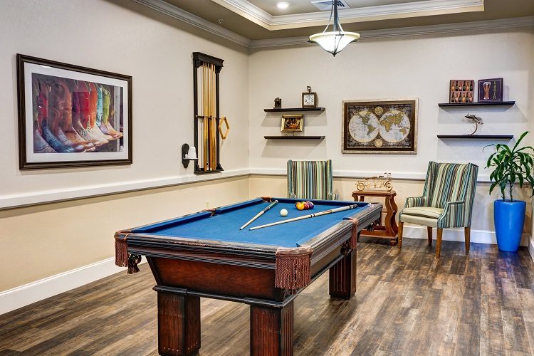 A stylish billiard room featuring a pool table and elegant furnishings.