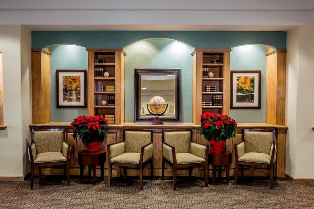 A neatly arranged waiting room featuring chairs, poinsettias, and wall decor.