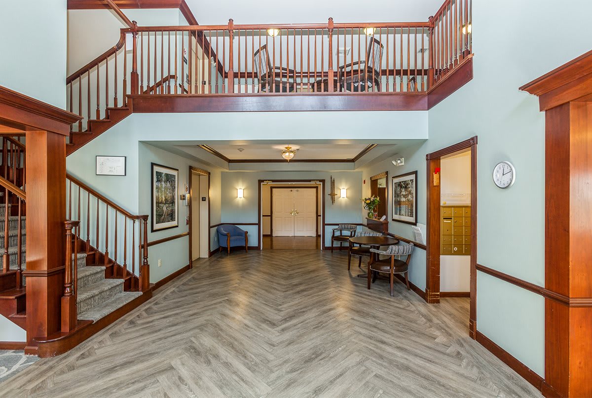 Spacious lobby with a staircase, seating area, and artwork on the walls.