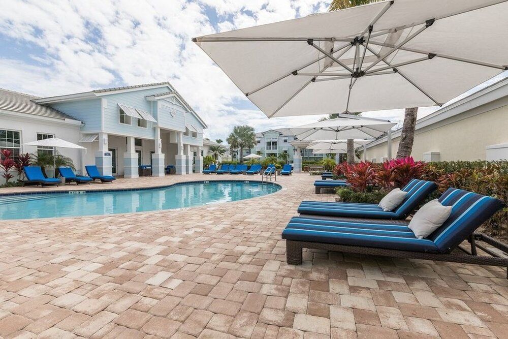 A relaxing poolside area with sun loungers and umbrellas at a resort.