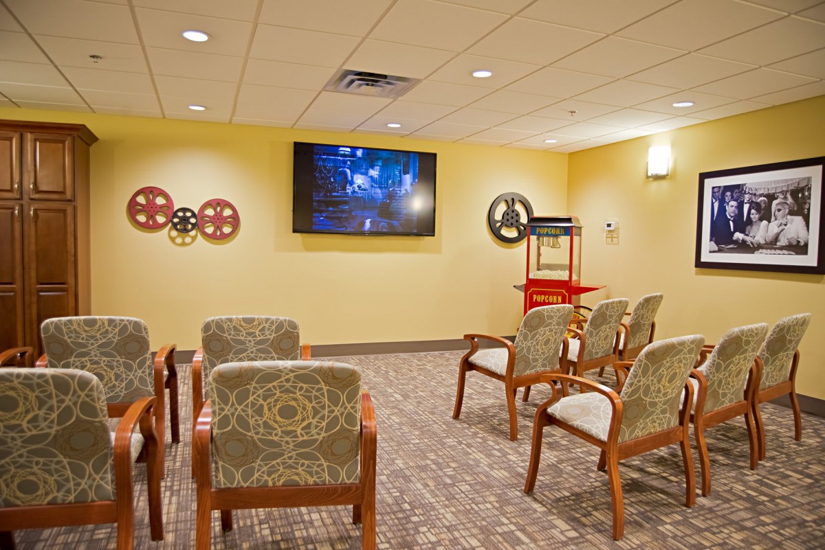 A cozy home theater setup with comfortable seating and a popcorn machine.