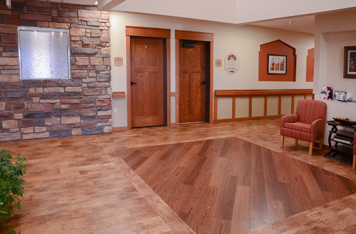 A welcoming lobby featuring wooden doors, a stone accent wall, and stylish flooring.