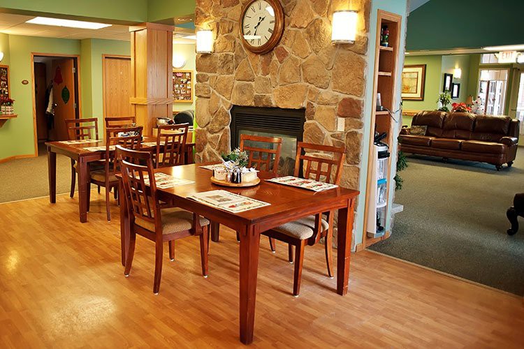 A cozy dining area with wooden furniture and a stone fireplace.
