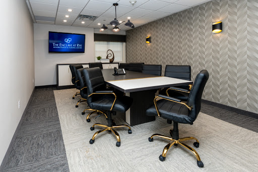 A modern conference room designed for meetings, featuring a large table and comfortable black chairs.