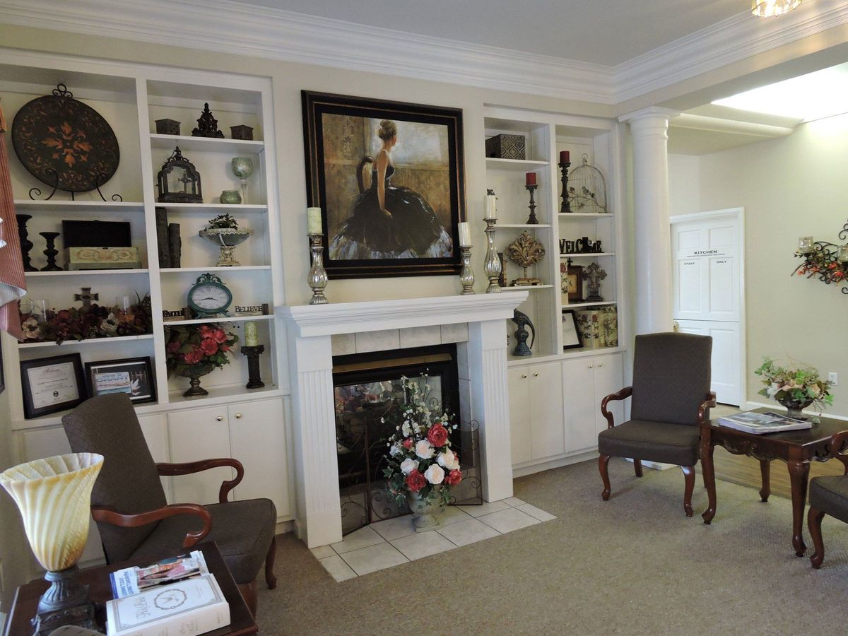 A cozy living room with a fireplace and decorative shelves.